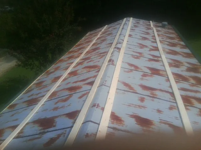 Rusted metal roof panels with new wood purlins before replacement — Storm Damage Roof Repair in Morning View by Roofing Brothers