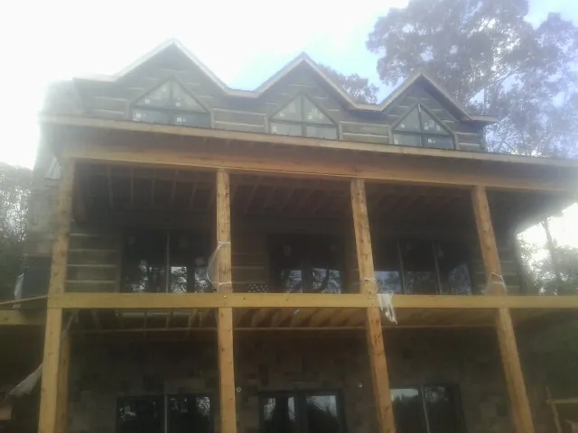 Dormers and porch framing on a large log home under construction in Morning View