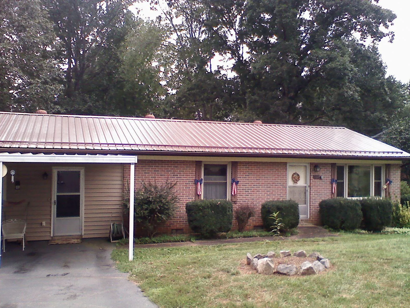 Bronze metal roof and carport on a brick ranch home — Roof Repair work by our crew in Morning View